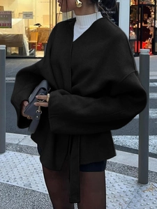 Détail de style urbain d'un élégant blazer noir à manches longues avec ceinture à la taille