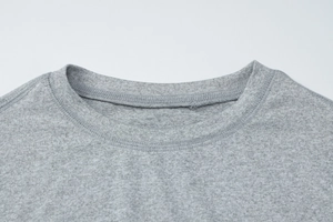 Detailed macro view of the crew neck stitching and grey knitted fabric texture on the top