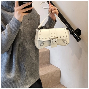 White PU leather motorcycle bag with silver rivets and buckles in a lifestyle setting