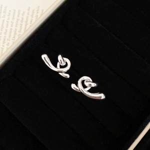 Détail de boucles d'oreilles nœud torsadé en argent avec finition polie sur velours noir