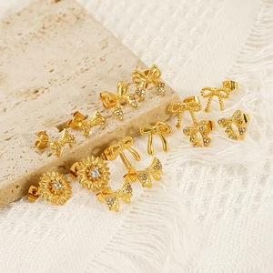 Gold bow earrings and floral studs with sparkling rhinestones on an elegant background