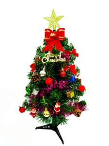 Mini Christmas tree detail with colorful baubles, gold star topper, and red ribbons