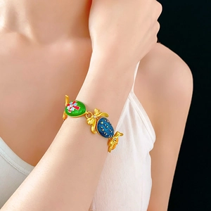 Dettaglio del bracciale vintage in smalto con perline verdi e blu e strass lucidi
