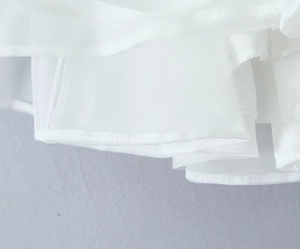 Détail des couches de tulle blanc multicouches et du tissu en polyester de la robe