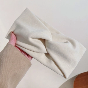 Gros plan sur un bandeau en tweed blanc cassé avec nœud torsadé et texture douce