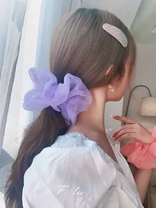 Detail of purple organza scrunchie on model with a soft translucent texture and high volume