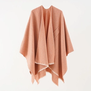 Detailed view of pink knitted cashmere shawl with fringe hem and functional pocket detail
