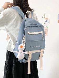 Student backpack in dusty blue with beige straps and a cute plush duck charm
