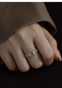 Close-up of a minimalist hollow geometric silver ring worn on a finger