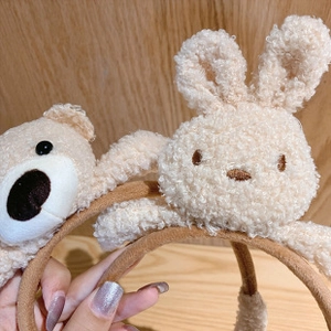 Close-up of plush bear and rabbit bow headbands with soft brown fabric wrap details