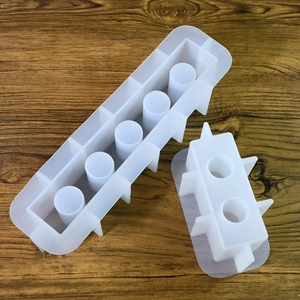 Détail de moules en silicone épais à 5 et 2 trous pour vases en résine sur fond de bois
