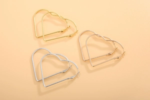 Detailed view of heart-shaped hoop earrings in gold, silver, and rose gold finishes