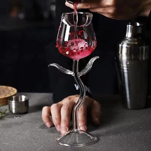 Elegant rose shaped wine glass with a curved stem and red liquid poured inside