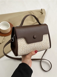 Sac à main en patchwork de cuir marron et paille sur fond de costume beige