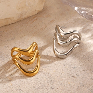Minimalist wavy multi-layer open rings in gold and silver finish on a natural stone background