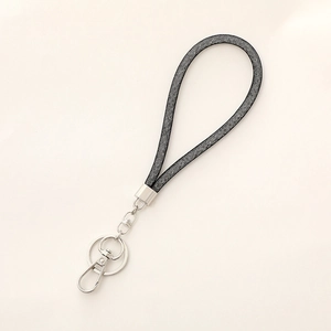 Close-up of black glitter wristlet strap with silver key ring and swivel clasp hook