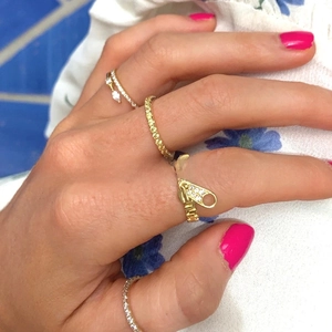 Detail of 18K gold plated zipper ring with zircon pavé worn on a female finger