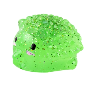 Sparkly green hedgehog squishy toy with gold glitter and soft texture on white background