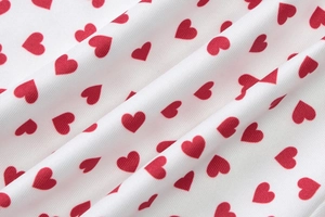 Détail du tissu en maille blanche douce avec des motifs de cœurs rouges