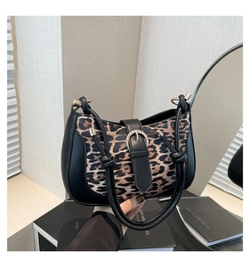 Detail of leopard print patchwork handbag with gold buckle and chic knotted handle