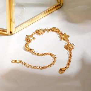 Detailed macro view of 18K gold stainless steel bracelet with sun moon and star charms
