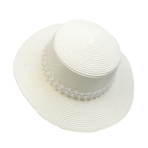 Detail of white straw hat featuring elegant pearl and lace trim decoration on the brim