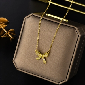 Elegant gold bow necklace with sparkling crystals presented in a premium jewelry box