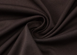 Macrodetail van donkerbruine geplooide stof met textuur en elegante gedrapeerde val