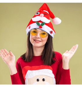 Close-up of thick plush Santa hat featuring cartoon embroidery and holly leaf detail