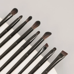 Detailed view of professional makeup brushes with black handles on a curved display stand