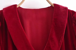 Gros plan du col en V et de la texture du tissu en velours bordeaux de la robe