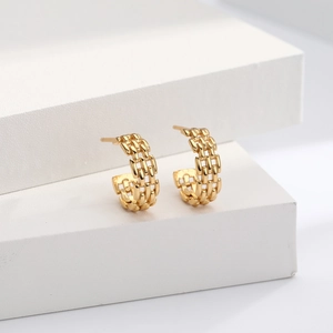 Close-up of golden C-shaped hoop earrings with unique triple-chain textured surface