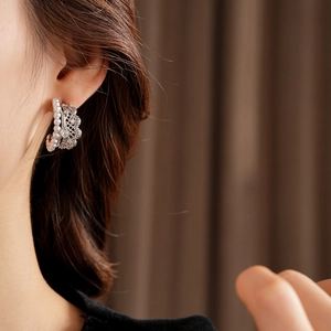 Detailed view of pearl lace earring with zircon stones on a model from a side angle