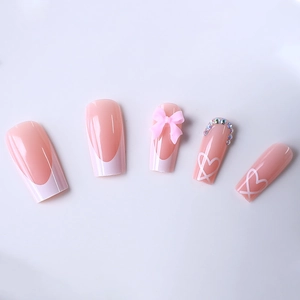 Long trapezoidal French nails with pink bows, white hearts, and sparkling rhinestones