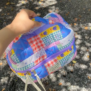Detailed shot of quilted floral cosmetic bag with patchwork patterns and ribbon zipper