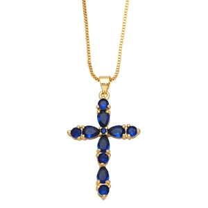 Detail of gold box chain necklace featuring a blue zircon cross pendant on white background