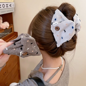 Detailed shot of pleated fabric scrunchie with handmade labels and rustic buttons