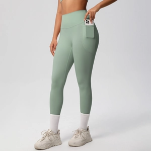 Detail of high-waisted sage green yoga pants featuring a large functional side pocket