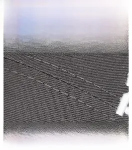 Detailed close-up of dark grey twill fabric with double stitching and white embroidery