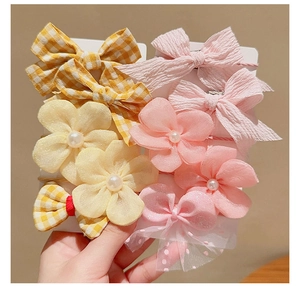 Detail showing bow hair clips and ties with yellow plaid and pink mesh with pearls