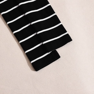 Close-up of black and white striped ribbed knit fabric showing detailed texture and cuffs