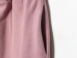 Détail du tissu en maille rose avec texture douce et couture de poche latérale