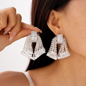 Macro detail of rhinestone bow tassel earrings with shimmering crystals on silver pins