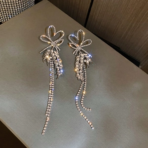 Macro shot of sparkling rhinestone heart bow tassels earrings with silver finish detail