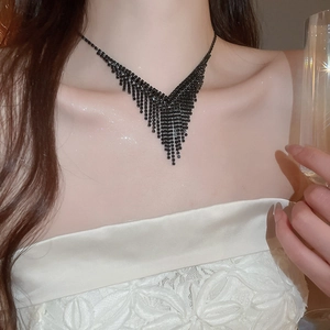 Détail d'un collier élégant noir en forme de V avec glands porté par un mannequin