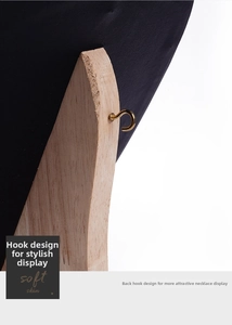Detail showing the wooden support and golden metal hook of a black necklace display stand