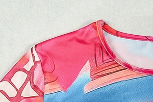 Detailed view of round neckline and shoulder stitching on abstract print mini dress