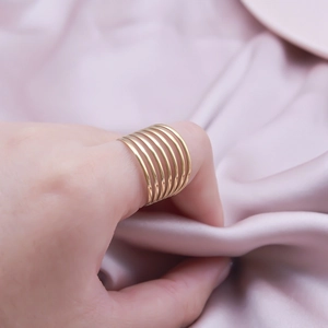 Minimalist multi-layer gold stainless steel ring worn on thumb with sleek geometric design
