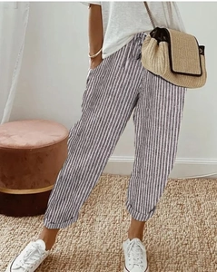 Detail van de gestreepte casual broek met elastische taille en geweven strooien tasje