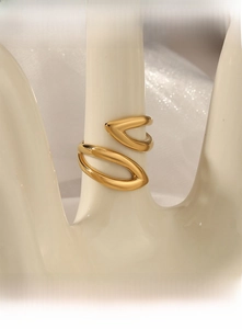 Close-up of golden leaf-shaped open ring displayed on a white hand-shaped jewelry holder